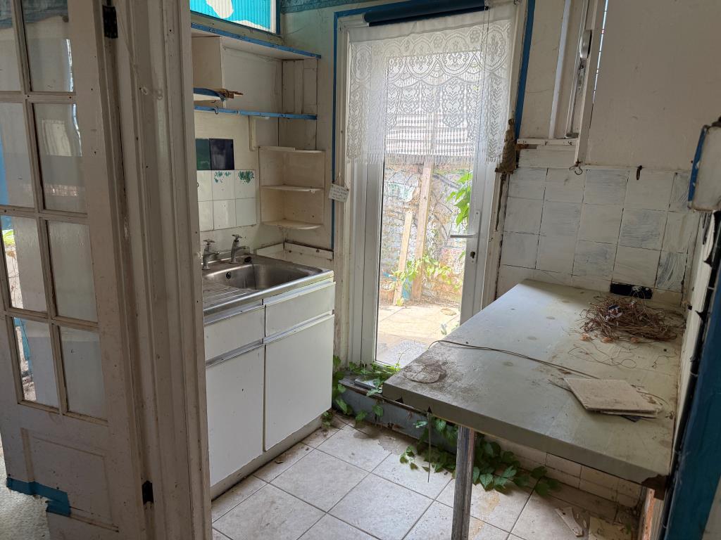 Kitchen with units and glazed side door to patio