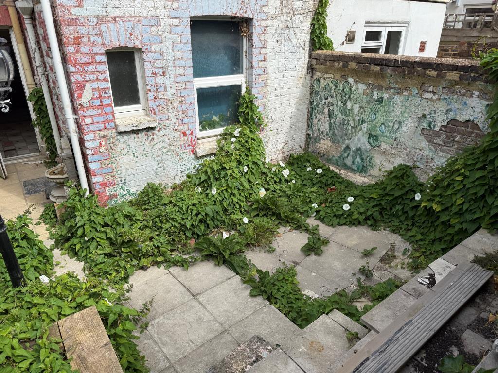Rear patio garden with paved area and wall
