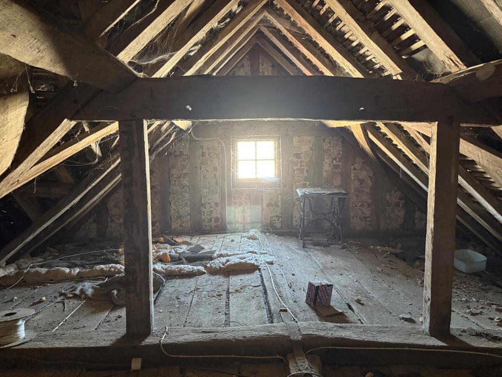 Loft space with front window and wooden vaulted be