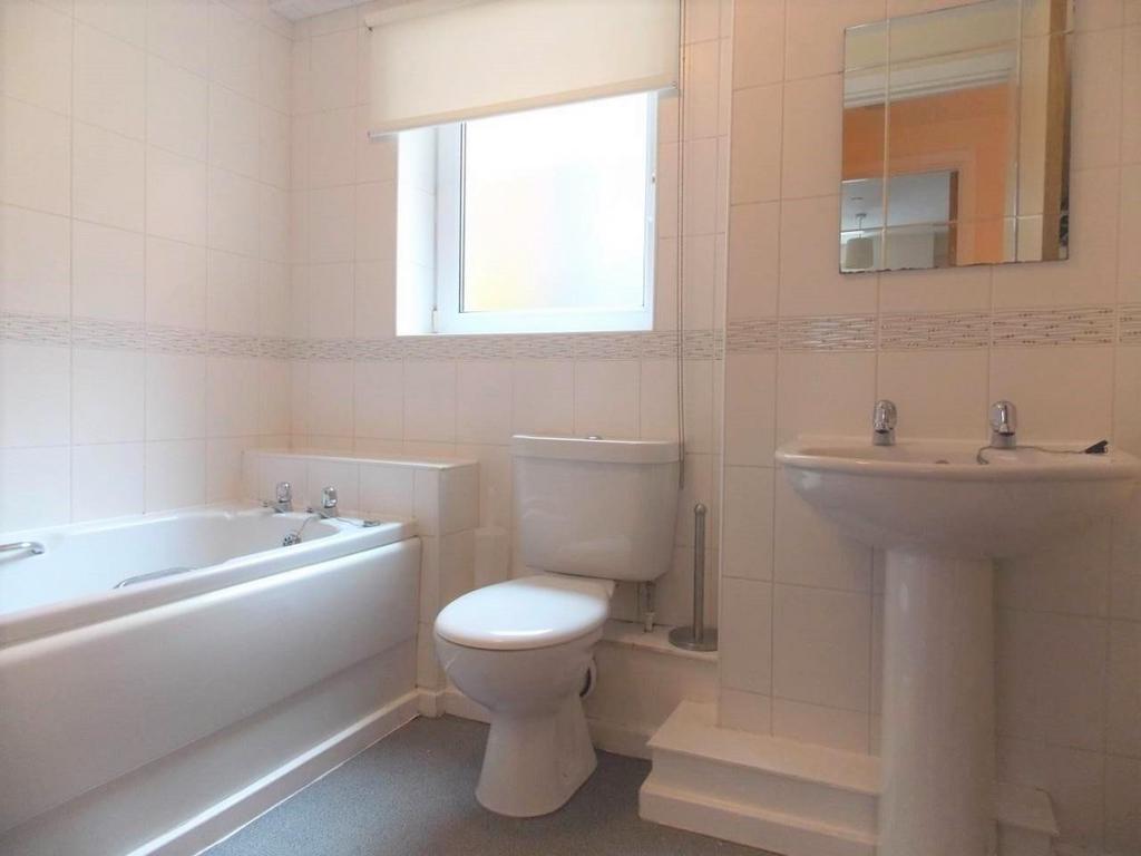 Bright and clean bathroom suite featuring a spa...