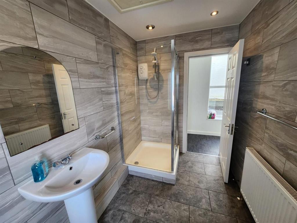 Modern bathroom with tiled walls and floor, ped...