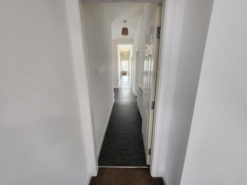 Bright, clean hallway with neutral white walls ...