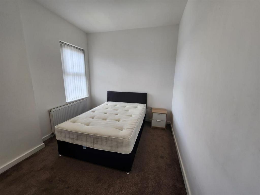 Bright, simply furnished bedroom with a double ...