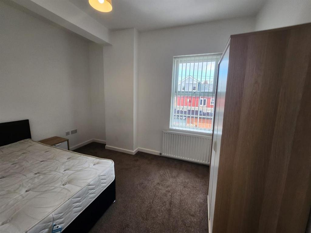 Bright, simply furnished bedroom with a double ...