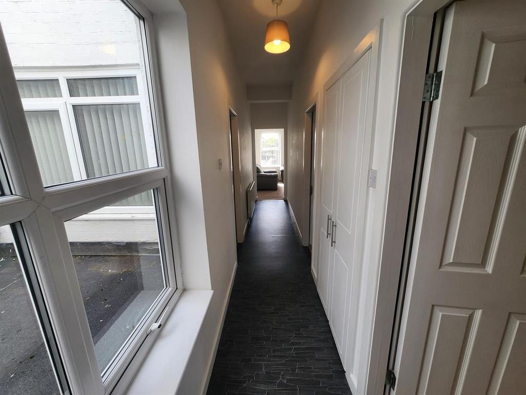 Bright interior hallway with a long carpeted co...