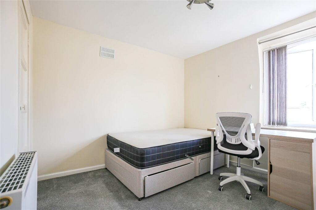 A bright and tidy single bedroom featuring a co...