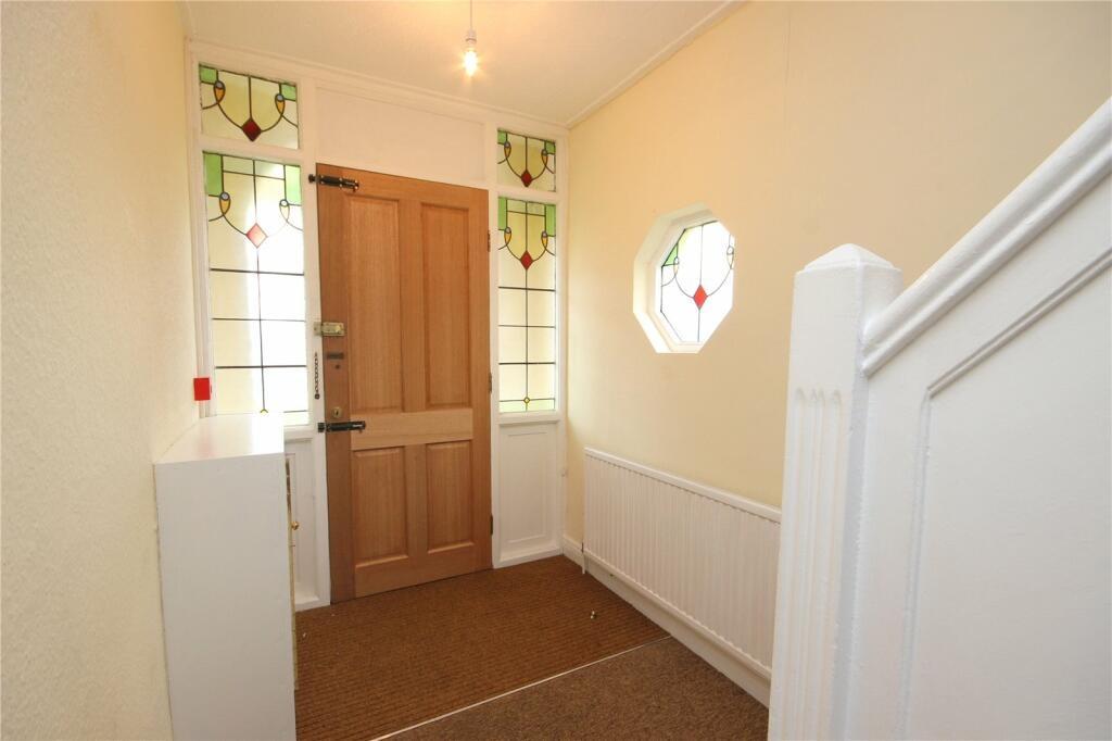 A bright and welcoming hallway featuring decora...