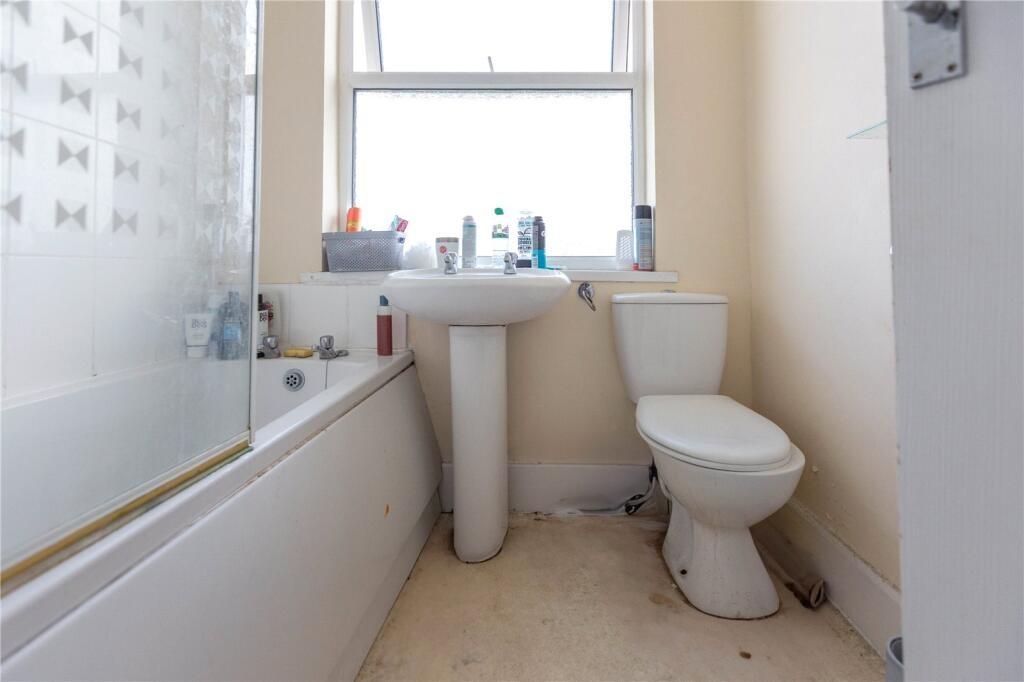 A bright bathroom suite featuring a bathtub wit...
