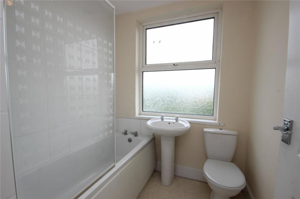 A clean and bright bathroom featuring a white b...