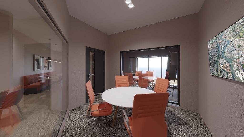 A modern communal workspace featuring a round w...