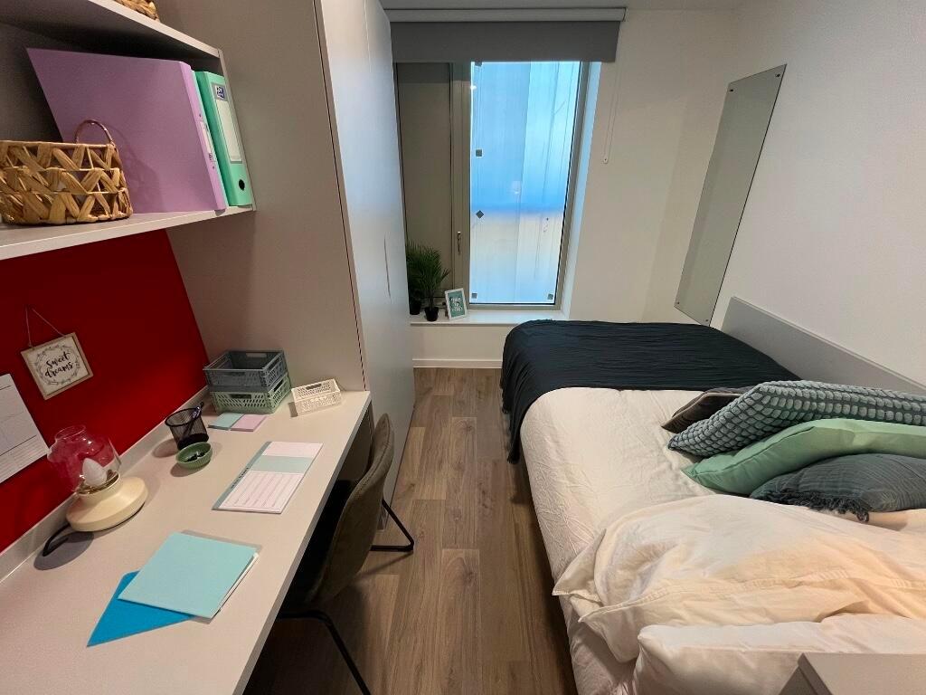 A neat and well-organized bedroom featuring a c...