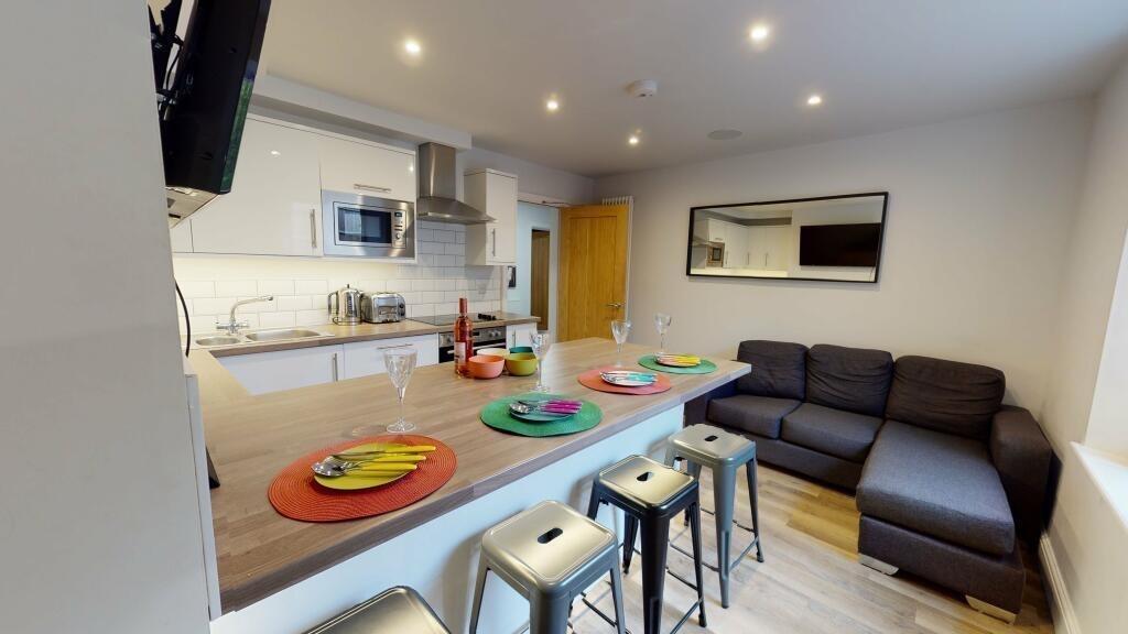 A modern open-plan living room and kitchen area...