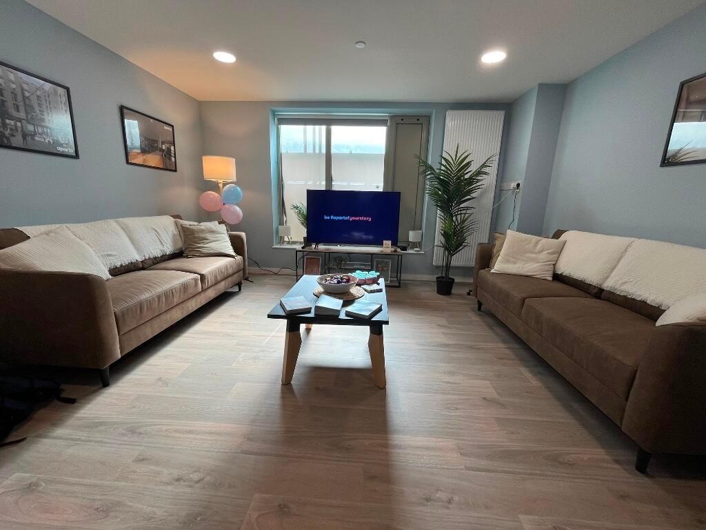 A spacious and modern living room featuring two...