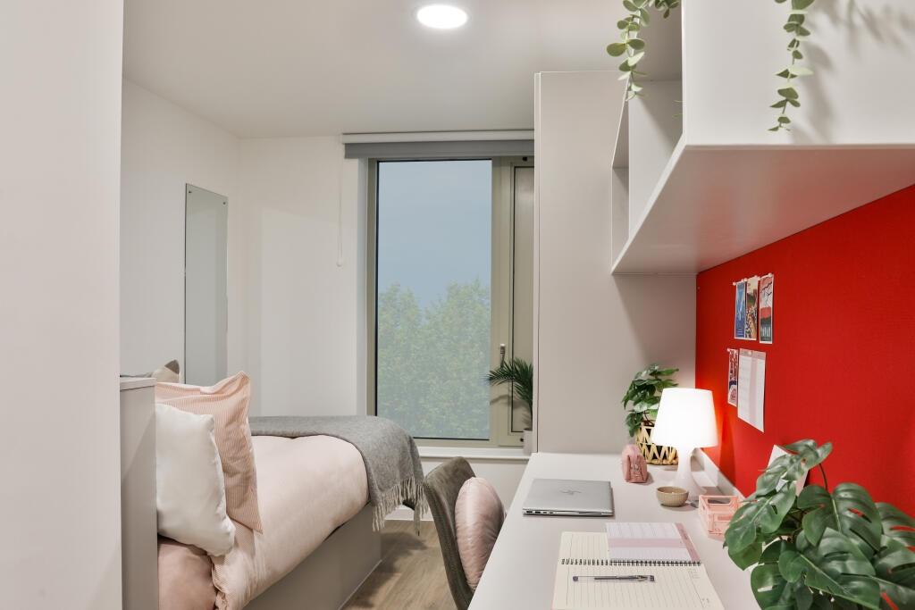 A bright and cozy single bedroom featuring a co...