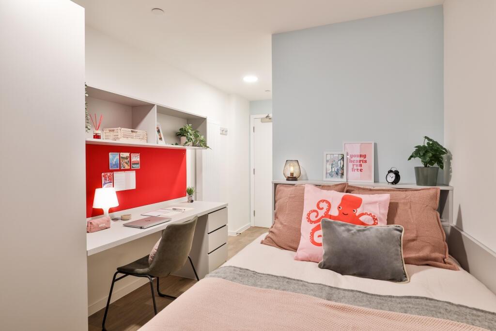 A cozy and well-organized single bedroom featur...