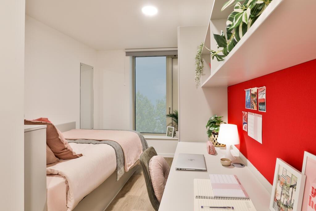 A clean and well-organized single bedroom featu...
