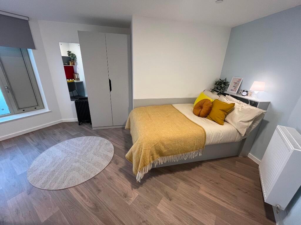 Bright and modern master bedroom featuring a co...