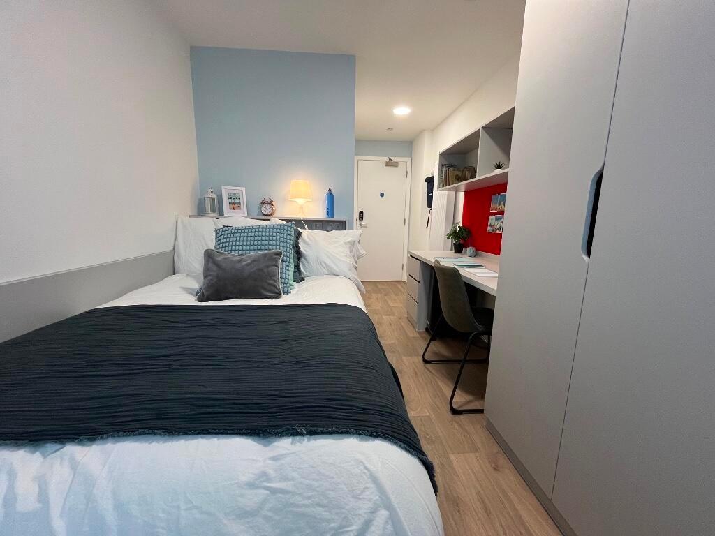 A modern, tidy single bedroom featuring a neatl...