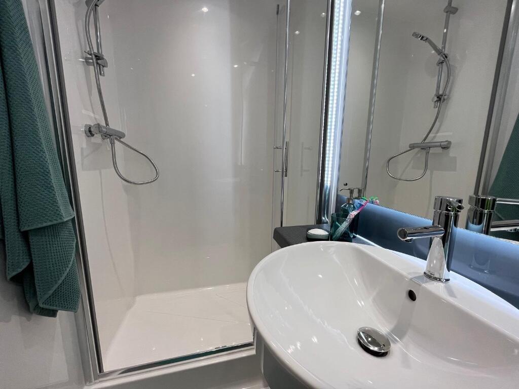 Modern and sleek bathroom suite featuring a spa...