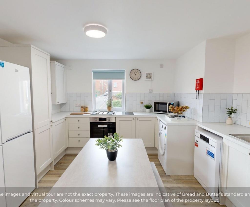 A modern and clean kitchen featuring white cabi...