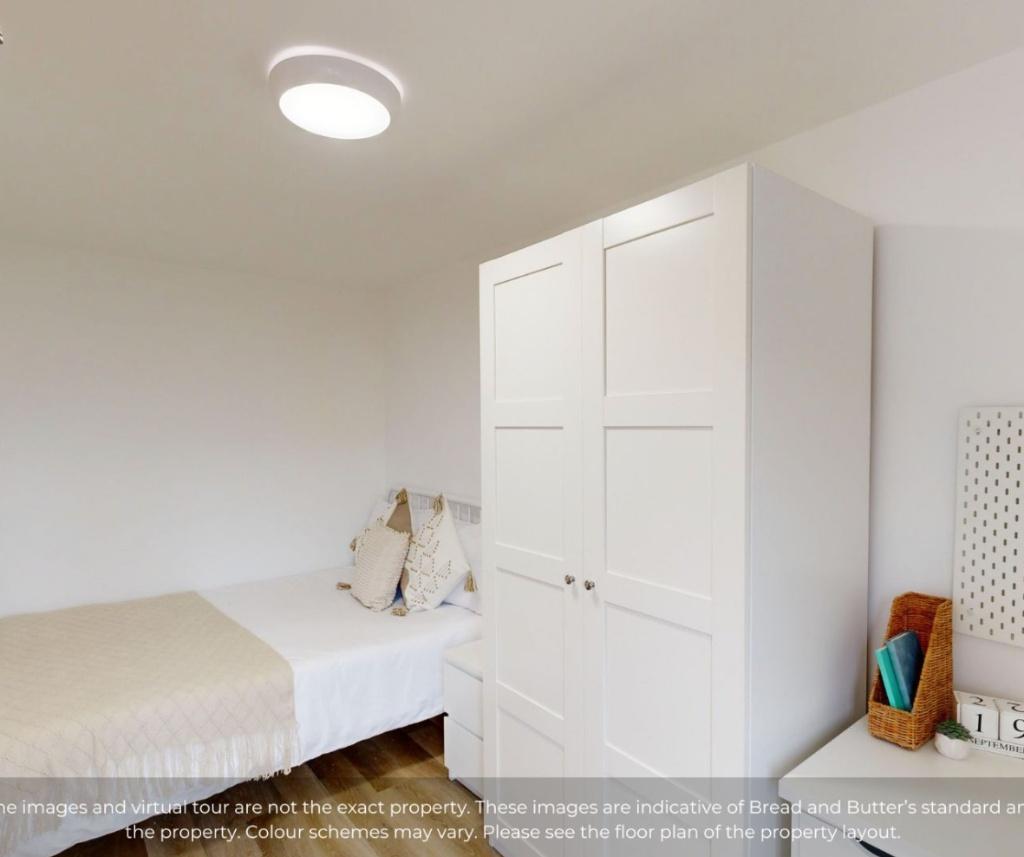 A clean and tidy single bedroom featuring a nea...