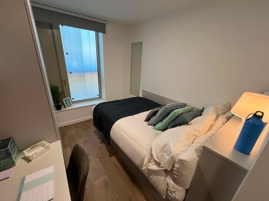 A clean and cozy double bedroom featuring a com...