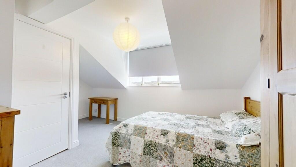 A cozy double bedroom with a floral bedspread, ...