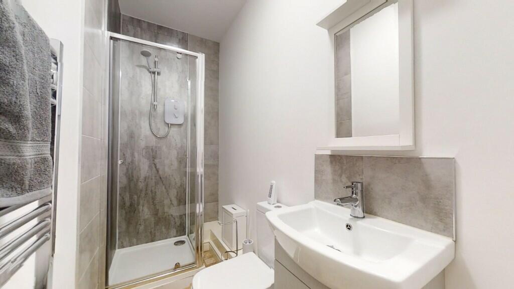 A modern bathroom featuring a sleek walk-in sho...