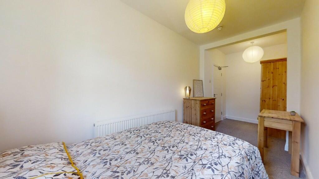 Bright and cozy master bedroom featuring a comf...