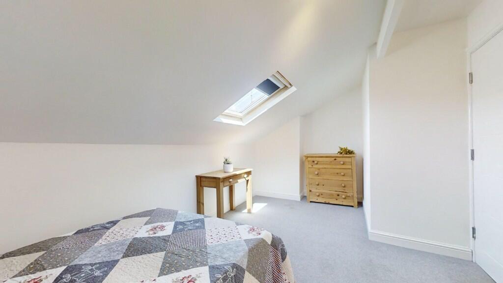Bright and cozy master bedroom featuring a comf...