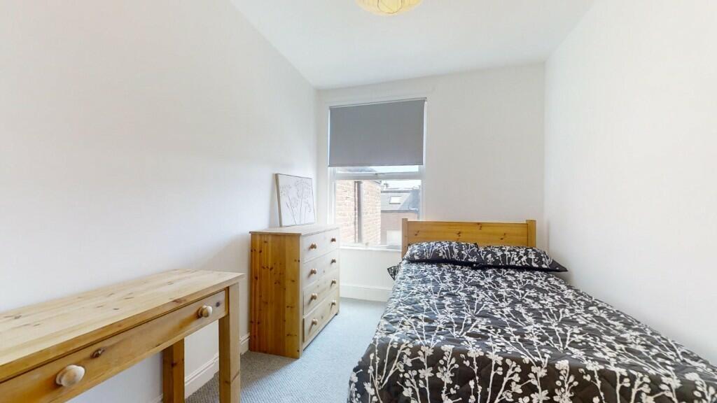 Bright and cozy single bedroom featuring a comf...