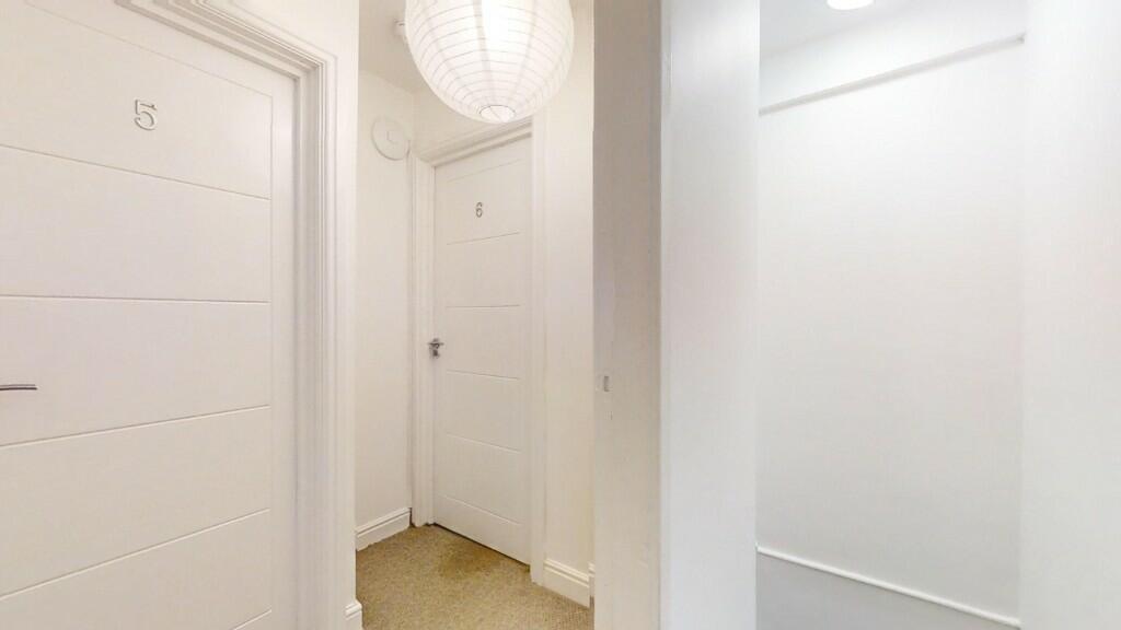 A clean and bright hallway with white walls and...