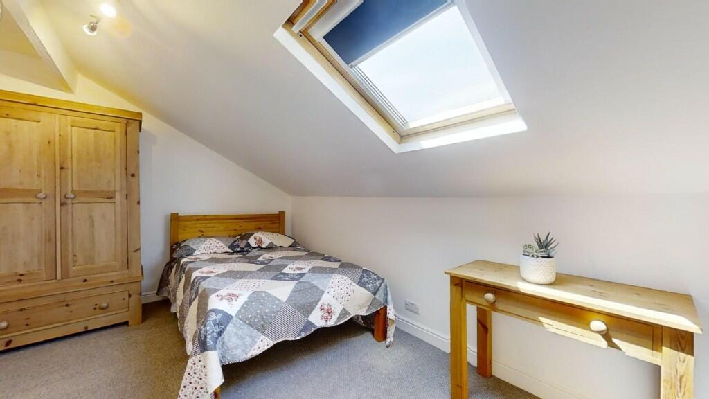 A bright and cozy single bedroom featuring a sl...