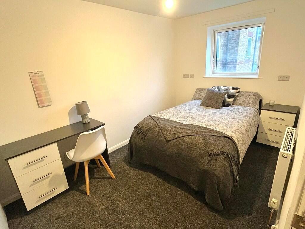 A cozy single bedroom featuring a comfortable b...