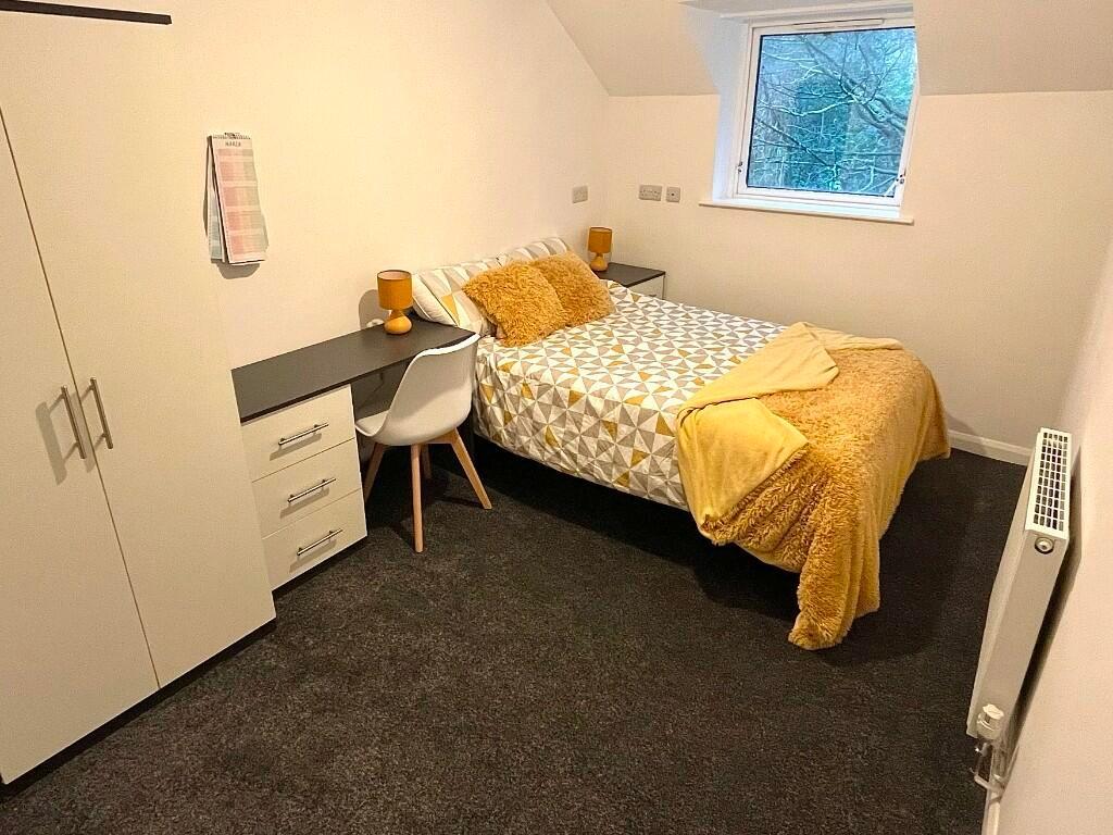 A cozy single bedroom featuring a comfortable b...