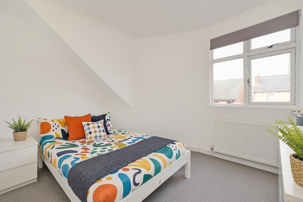 Bright and clean double bedroom featuring a col...