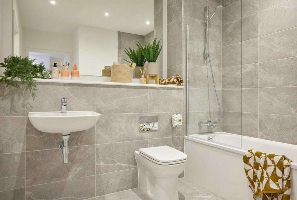 A clean and modern bathroom featuring a bath an...