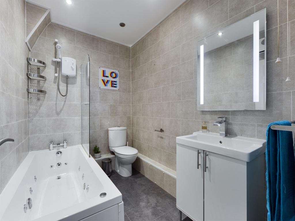 A modern and spacious bathroom featuring a luxu...