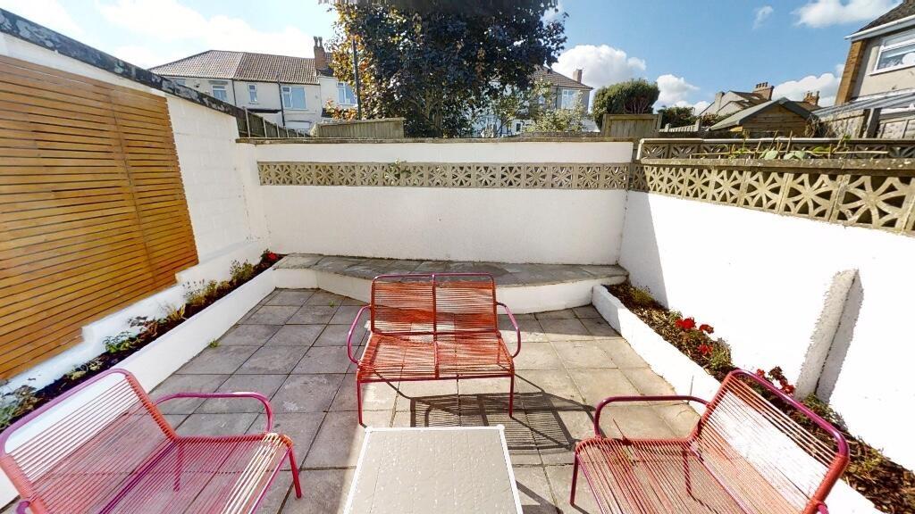 A bright outdoor garden patio featuring clean, ...