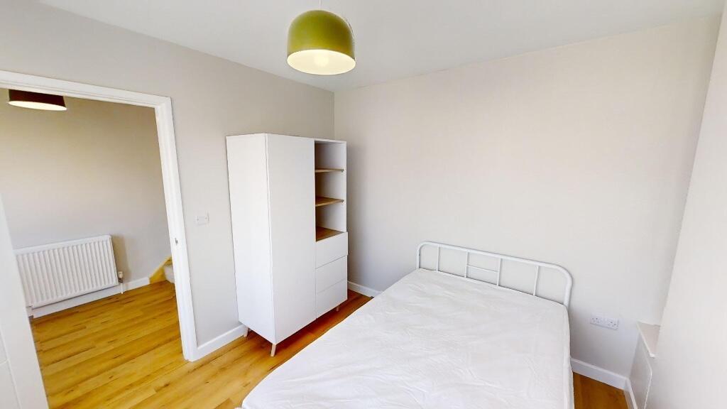 A bright and tidy single bedroom featuring a wh...