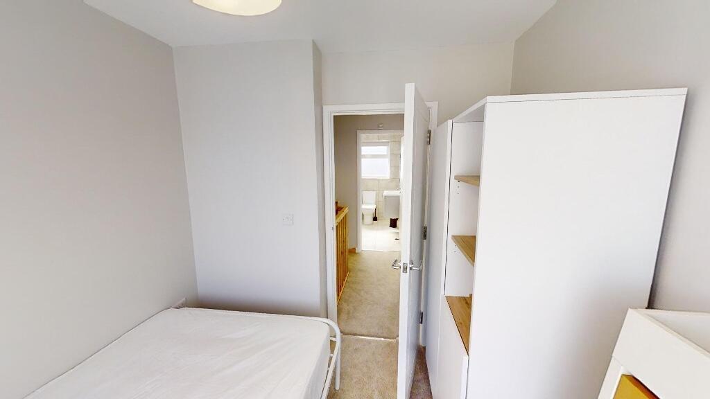 A neat and simple single bedroom featuring a de...