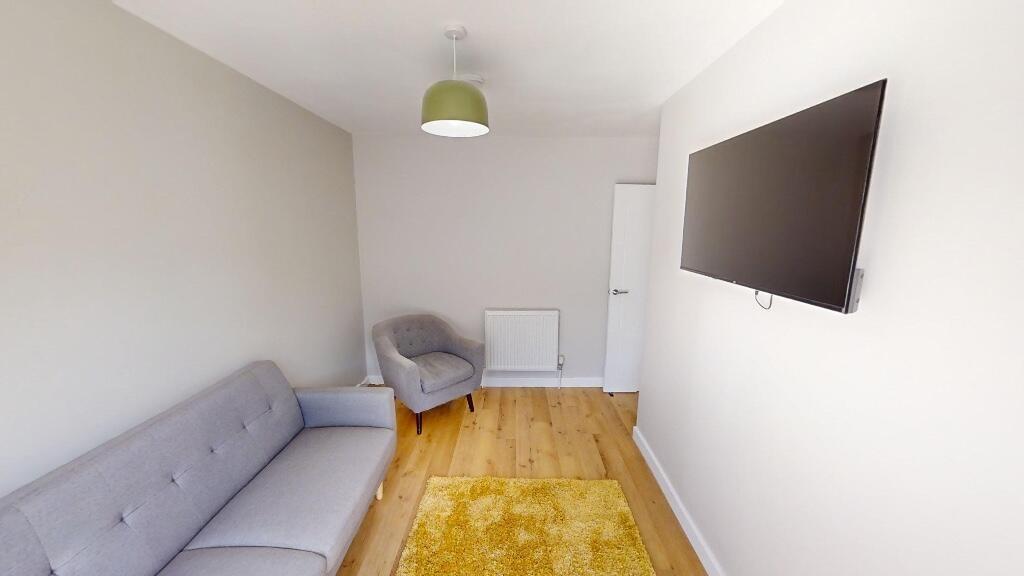 A neat and modern living room featuring a comfo...