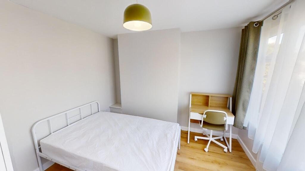 A bright and tidy single bedroom featuring a co...