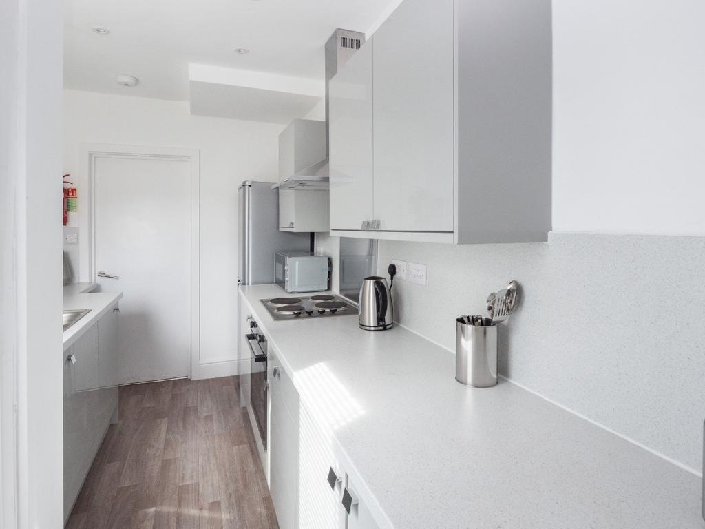 A modern kitchen featuring sleek white cabinetr...