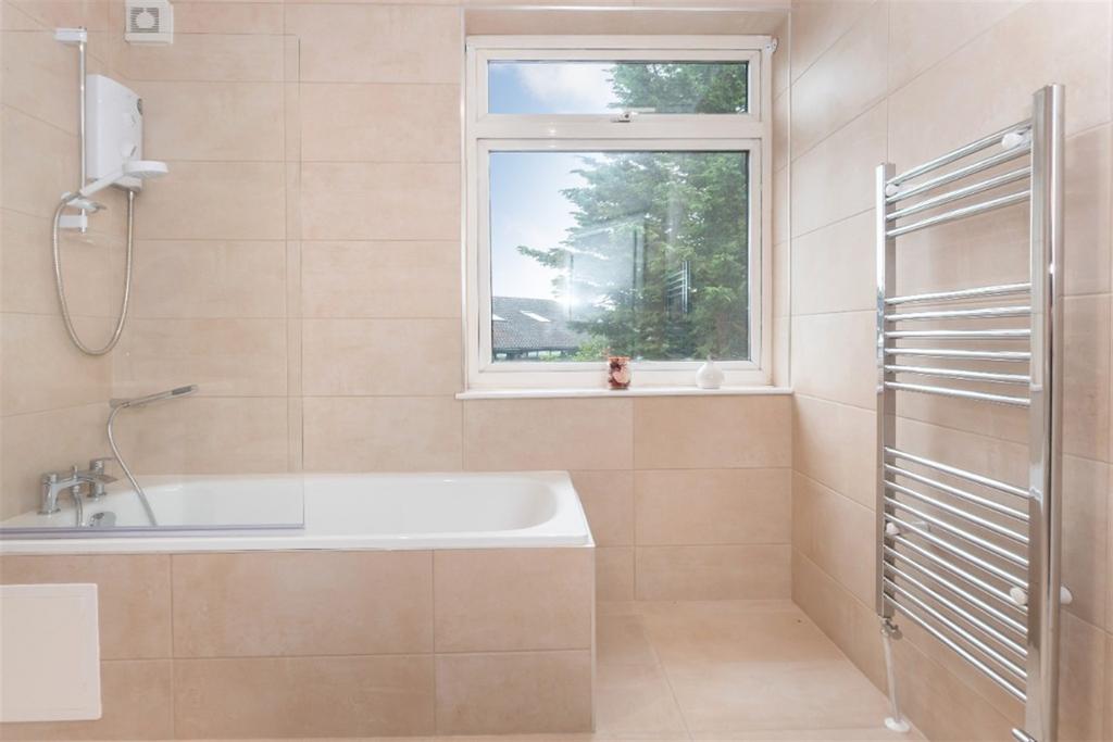 A bright and well-maintained bathroom suite fea...