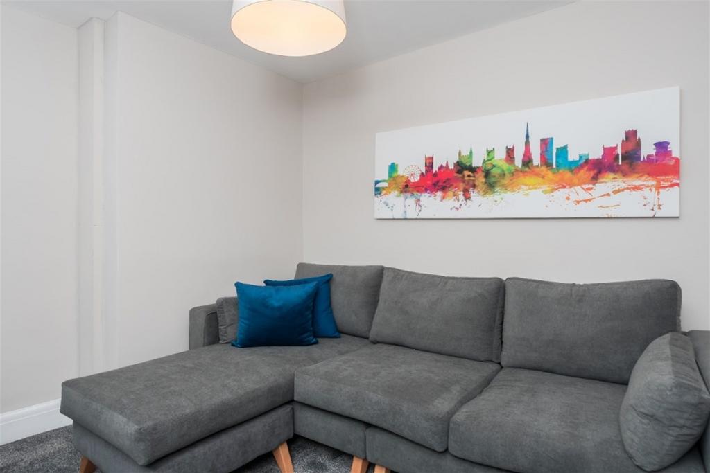 A cozy living room featuring a modern grey sect...