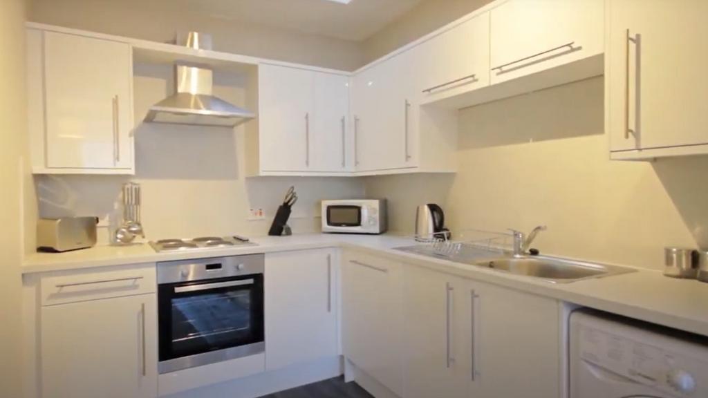 Bright and modern kitchen featuring white cabin...