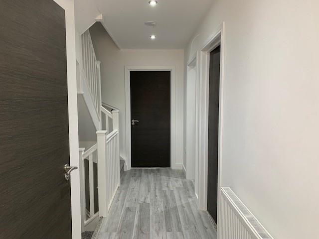 A clean and modern hallway with light grey floo...