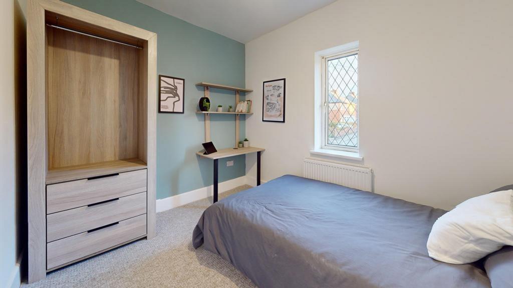 A bright and tidy double bedroom featuring a fi...