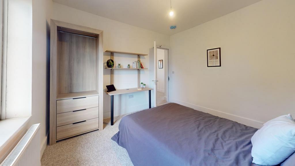 A spacious and tidy double bedroom featuring a ...
